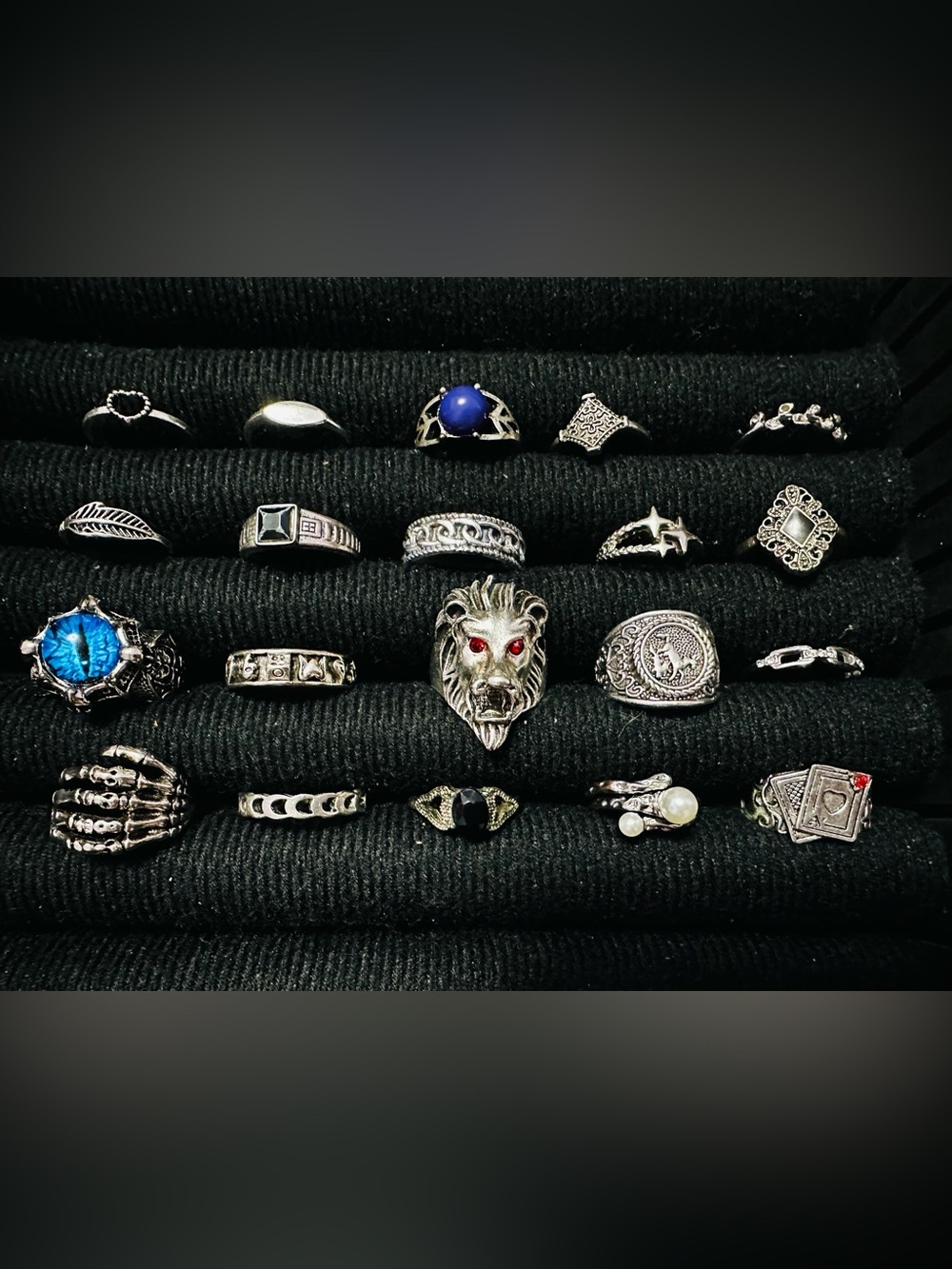 Assorted rings, including lion head, eye, and playing card designs.